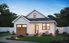 a small white house with two windows and lights on the front door is lit up at night