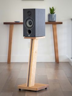 a pair of speakers sitting on top of a wooden stand