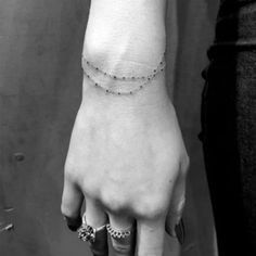 black and white photo of a woman's arm with a tattoo on the wrist