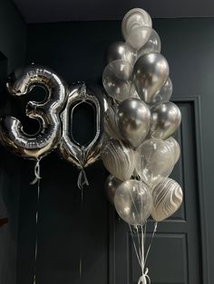 balloons and numbers are hanging on the door to celebrate someone's 30th birthday or anniversary