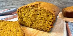 a loaf of pumpkin bread sitting on top of a cutting board next to another loaf