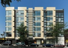 an apartment building with many windows and cars parked on the street