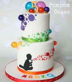 a three tiered cake decorated with balloons and confetti on the top layer