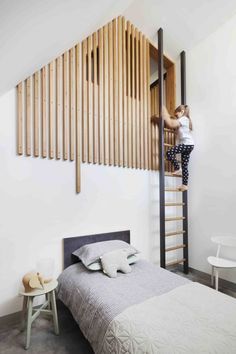 a woman climbing up the side of a wooden slatted wall next to a bed