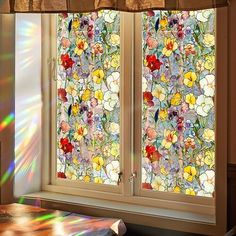 the sun shines brightly through two stained glass windows with floral designs on them, in front of a window sill