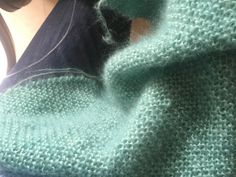 a close up view of someone's green sweater