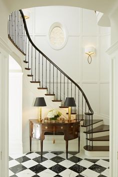 a foyer with a checkered floor and black and white tiles on the floor, along with a staircase