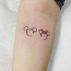 a woman's arm with two minnie mouse tattoos on it