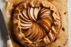 an apple pie with slices cut out sitting on top of a piece of parchment paper