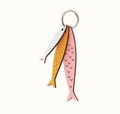 a pink and yellow fish shaped keychain on a white background with a hook in the shape of a fish