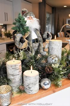 a santa clause figurine sitting on top of a table next to christmas decorations