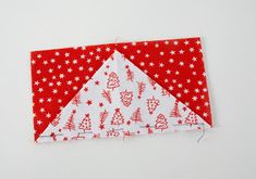 a piece of red and white fabric with christmas trees on it