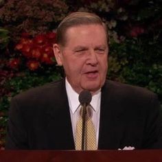 a man in a suit and tie speaking at a podium