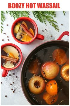 two red mugs filled with hot water and apples next to cinnamon sticks on the side