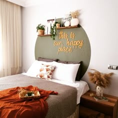 this is our happy place sign on the wall above the bed with pillows and blankets