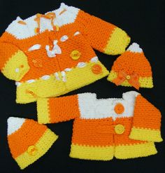 an orange and white crocheted outfit with matching booties is displayed on a black surface