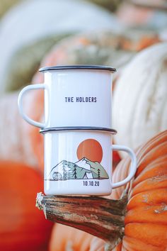 two mugs sitting on top of each other in front of pumpkins and squash