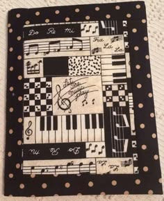 a black and white patchwork quilt with musical notes on it, along with polka dots