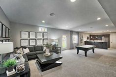 a living room filled with furniture and a pool table in the middle of the room