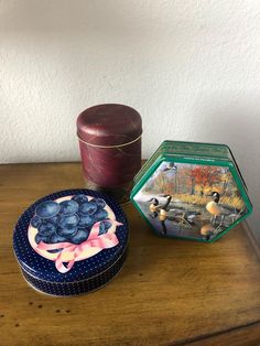 a wooden table topped with a cake next to a box of blueberries and a candle