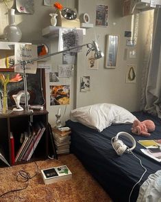 a bed room with a neatly made bed and lots of clutter on the walls