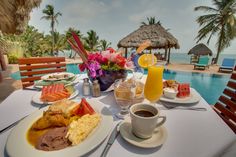 a table with food and drinks on it next to a pool