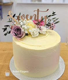 a white cake with flowers and the word sweet on top is sitting on a table