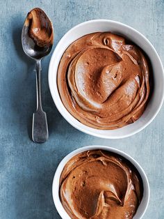 two bowls filled with peanut butter next to a spoon