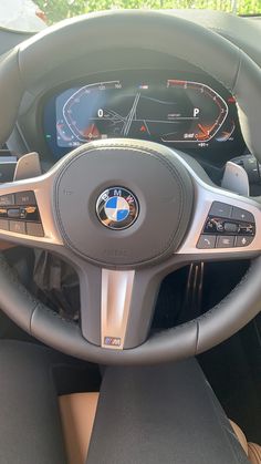 the steering wheel and dashboard of a bmw car with digital display on it's dash board