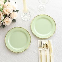 the table is set with plates, silverware and flowers