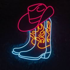 a neon cowboy boot with a hat on it's head is lit up in the dark