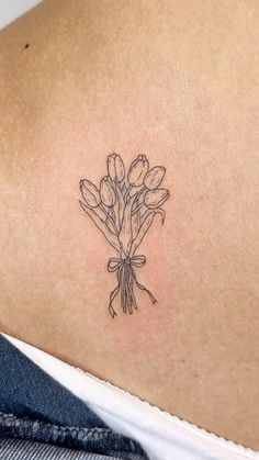 a woman's back with a tattoo on her shoulder and flowers in the center