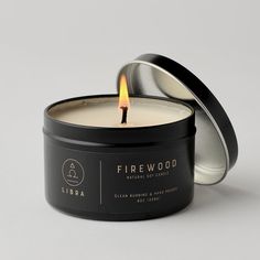 a candle that is inside of a tin on a white surface with the lid open