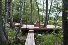 a wooden deck surrounded by trees in the woods