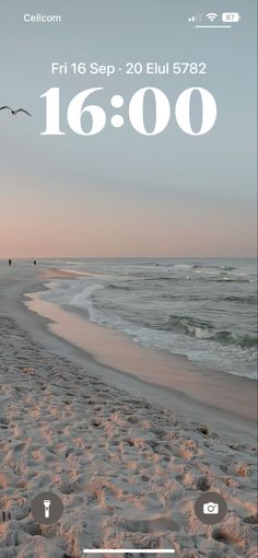 the beach is covered in sand and birds are flying over it, with an alarm clock displayed on the screen