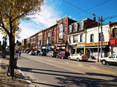 cars are parked on the street in front of shops and businesses along with power lines