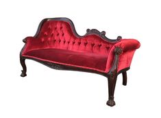 an old fashioned red velvet couch with ornate carvings on the armrests and back