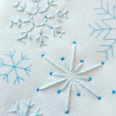 the snowflakes are made out of white fabric and blue thread, which has been stitched together