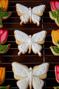 cookies decorated with flowers and butterflies on a cooling rack