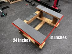 the bench is made out of wood and has red tape around it to show measurements