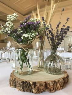 two vases filled with flowers sitting on top of a table