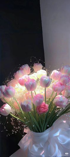 a white vase filled with lots of pink flowers