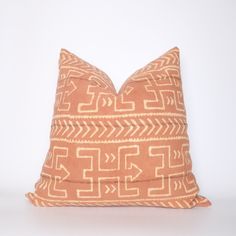 an orange and white pillow with arrows on it's side, against a white background