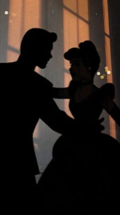 the silhouette of a man and woman standing next to each other in front of a window