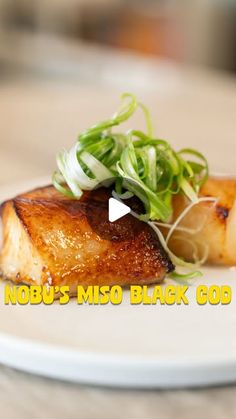 a white plate topped with meat and veggies next to the words nodbus miso black god