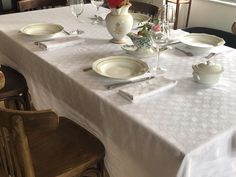 the table is set with white dishes and silverware