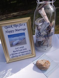 a table topped with a jar filled with sand and seashells next to a sign that says quick tips for a happy marriage