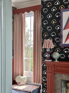 a living room with black and pink wallpaper, a fireplace and chair in front of the window