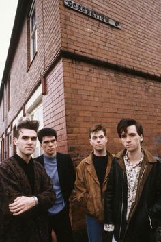 four young men standing in front of a brick building