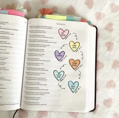 an open book with colorful hearts on it